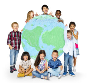 A group of diverse, cheerful children posing together with a large drawing of the Earth, representing global unity and friendship