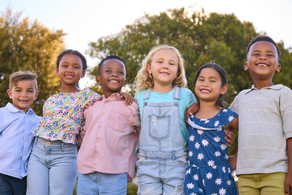 Group of diverse children smiling, representing the stages of cognitive development in children.